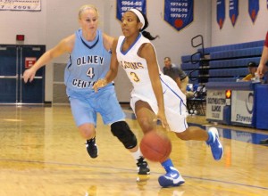  SIC’s Nakaila Sheppard drives against Olney Central’s Kelsee Ennis. Sheppard had 11 points, but SIC fell 91-75. 