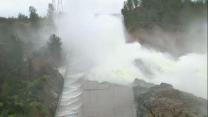 Water gushes over the emergency spillway of Oroville dam.  With heavy rains approaching, the threat of failure still remains.  (AP file photo)